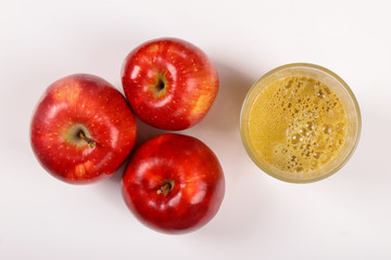 Red apples and a glass of fresh juice isolated on white background
