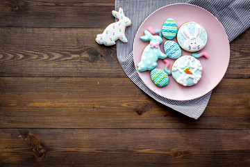Fototapeta na wymiar Easter bunny and easter eggs cookies. Sweets, pastry for Easter table. Dark wooden background top view copy space