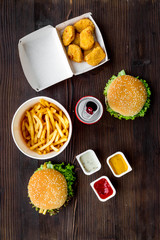 Most popular fast food meal. Chiken nuggets, burgers and french fries on dark wooden background top view © 9dreamstudio