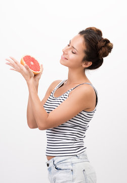Joyful young woman holding a grapefruit. Healthy, natural food