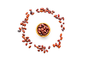 Roasted cocoa beans on white background top view copy space. Raw material for cocoa powder. African or Latin American product.