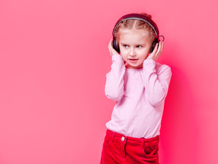 Little girl in headphones over rose background