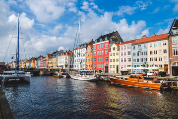 Naklejka premium September, 24th, 2015 - Copenhagen, Denmark. Nuhavn harbor with colorful scandinavian houses and private boats reflected on the water of canal.