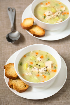 Chicken and potato chowder soup with green bell pepper and carrot, photographed with natural light (Selective Focus, Focus in the middle of the first soup)