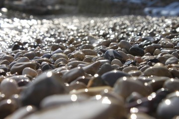 Obraz premium Shimmering sun glares on pebble seabed