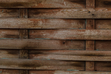 Texture of old wooden wicker fence with stains of paint