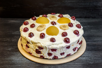 jelly cake with cherries on a wooden background.