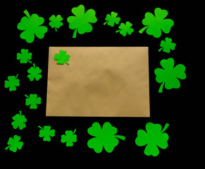 St. Patrick's Day. Envelope with green clover leaves on black background