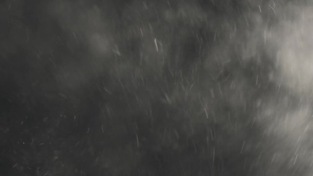 black and white backlit dust particles explosion and floating in slow motion