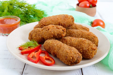 Juicy meat cutlets with a crisp on a ceramic plate with tomato sauce.