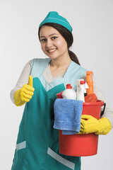 Young woman holding cleaning tools and products in bucket