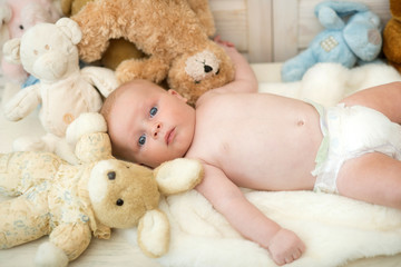 Childhood and curiosity concept. Baby boy with his soft toys