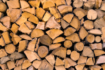 Material for heating the house. Preparation of firewood for the winter. background of firewood. A pile of firewood.