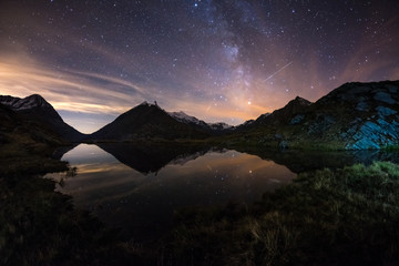 Milky Way starry sky reflected on lake at high altitude on the Alps. Fisheye scenic distortion and...