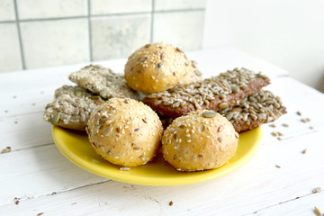 Bread buns with various seeds on white wooden table. Bread roll and breadsticks with sesame, pumpkin, sunflower, flax seeds