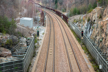 View from above of double railroad tracks in a mountain and forest evironment.