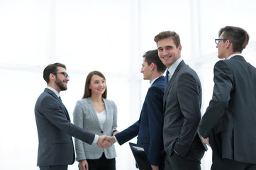 Business handshake. Two  cheerful businessman shaking hands in o