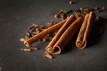 Spices and canella on the black wood background.