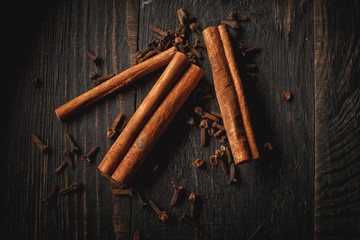 Spices and canella on the black wood background.