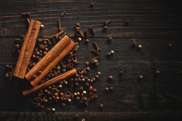Spices and canella on the black wood background.