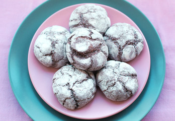 Chocolate cookies on plate onpink tablecloth, top view. Food, junk-food, culinary, baking and eating concept.