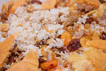 Shah Pilaf with fire on a table in restaurant . Shah pilaf. Khan pilaf in a pita. Pilaff . Pilau . Pilaw . Traditional oriental dish . on tableware . Azerbaijan , Baku .