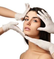 Naklejka premium Beautiful young woman face plastic surgery and doctor hands in medical gloves