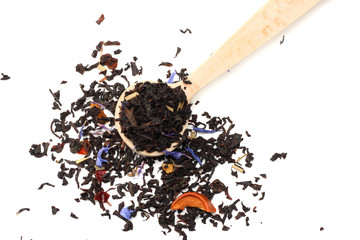 Aromatic black dry tea with petals in wooden spoon isolated on white background
