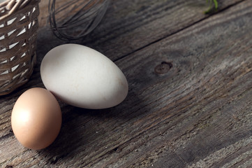 Goose and hen eggs on wooden table