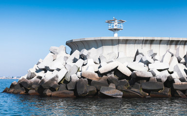 Obraz premium White beacon on concrete breakwater