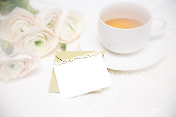 Fototapeta na wymiar Bouquet of flowers with cup of tea and love letter. Invitation card. Valentines day card.