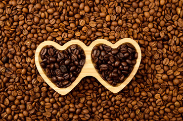 roasted coffee beans with wooden heart plate. View fromd above.