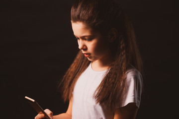 young sad vulnerable girl using mobile phone scared and desperate suffering online abuse cyberbullying being stalked
