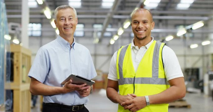 4k, Portrait of a Mature manger and delivery man in a large distribution warehouse. Slow motion.
