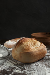 freshly baked bread on a wooden table on a dark background