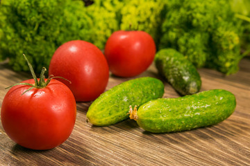 Fresh vegetables. Tomatoes and cucumbers on a wooden table