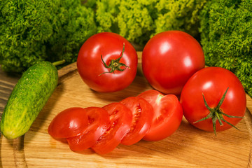Tomatoes and cucumber. Fresh vegetables on a wooden table.