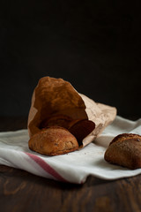 freshly baked bread on a wooden table on a dark background