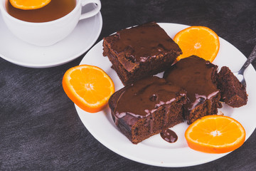 Chunks of Vegan chocolate homemade cake with slices of tangerines