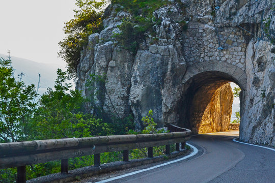 Narrow Italian road, Strada Della Forra, winding mountain route with tunnel in the alps, Tremosine, Lake Garda, Italy