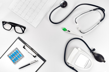 Stethoscope in the office of doctors.Top view of doctor's desk table, blank paper on clipboard with pen. Copy space. Designer's blank