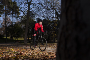 cyclist riding in the park with leaves on the ground in autumn 03