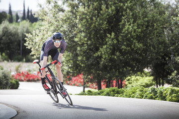 cyclist riding hard near the park with flowers