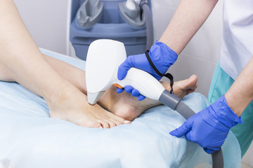 The process of laser depilation of female limbs in the beauty salon