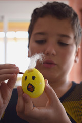 El niño esta pintando los huevos de pascua
