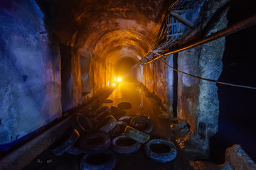 Abandoned flooded tunnel of cable collector, old rotten tires