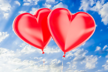 Fototapeta na wymiar Two red balloons in the shape of hearts flying on a blue sky, 3D rendering