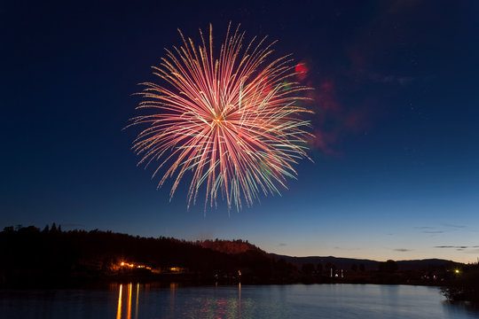 Celebration Fireworks Display Over a Mountain Lake at Dusk