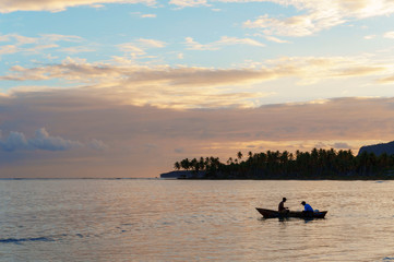 Fototapeta na wymiar two fishermen in a boat going fishing early in the morning at dawn