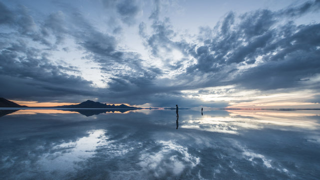 Fototapeta Symmetry view of lake against cloudy sky during sunset